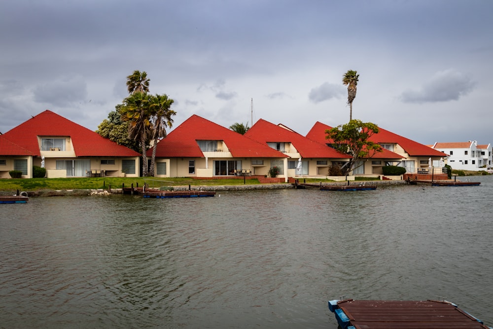 red and white house beside body of water during daytime