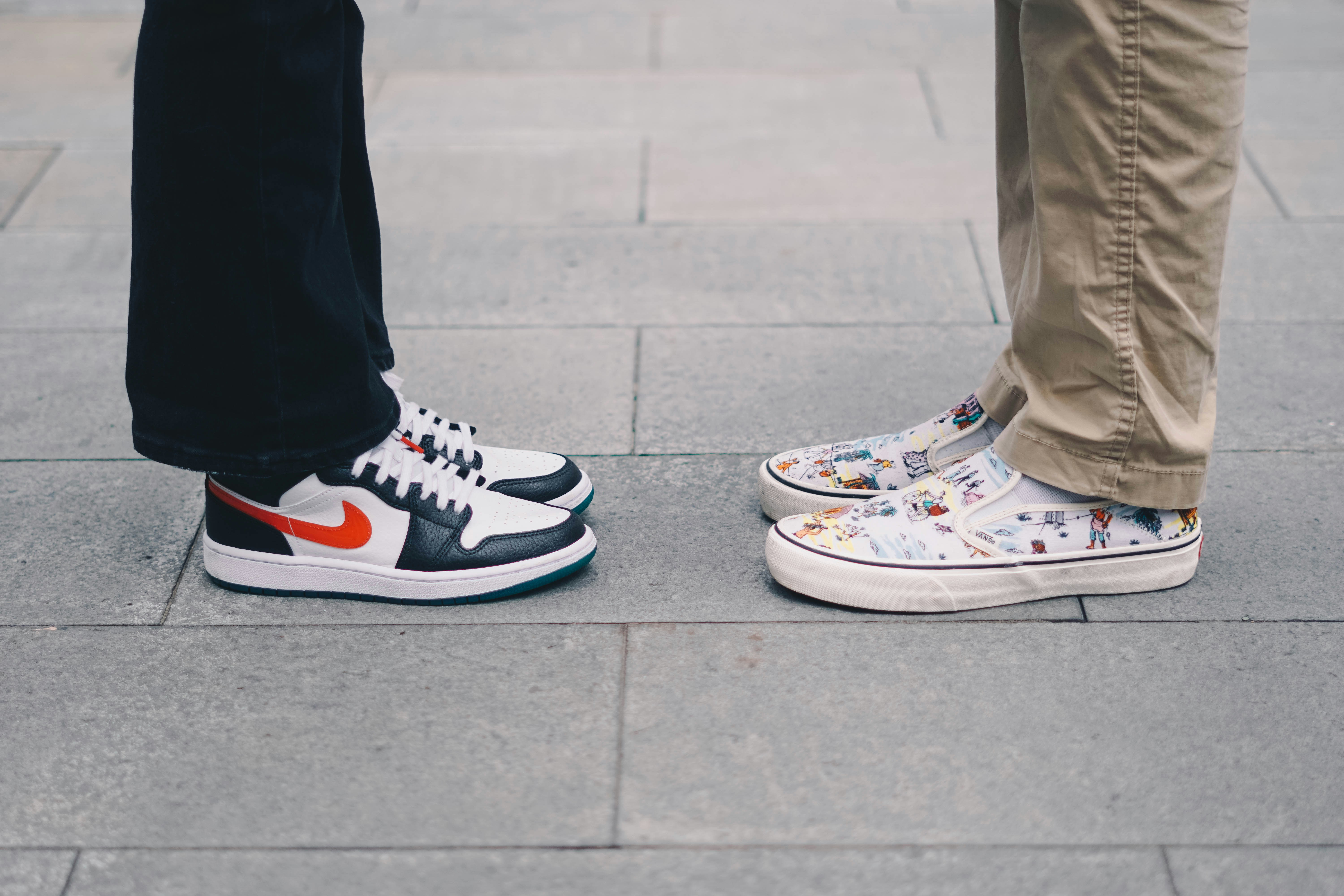 person wearing white and red converse all star high top sneakers