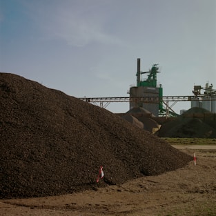 green metal machine on brown hill under white clouds during daytime