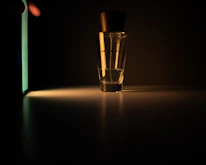 Close-up of a golden perfume spray releasing a fine mist in warm light.