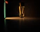 Close-up of a sleek black and gold perfume bottle glowing softly under warm light.
