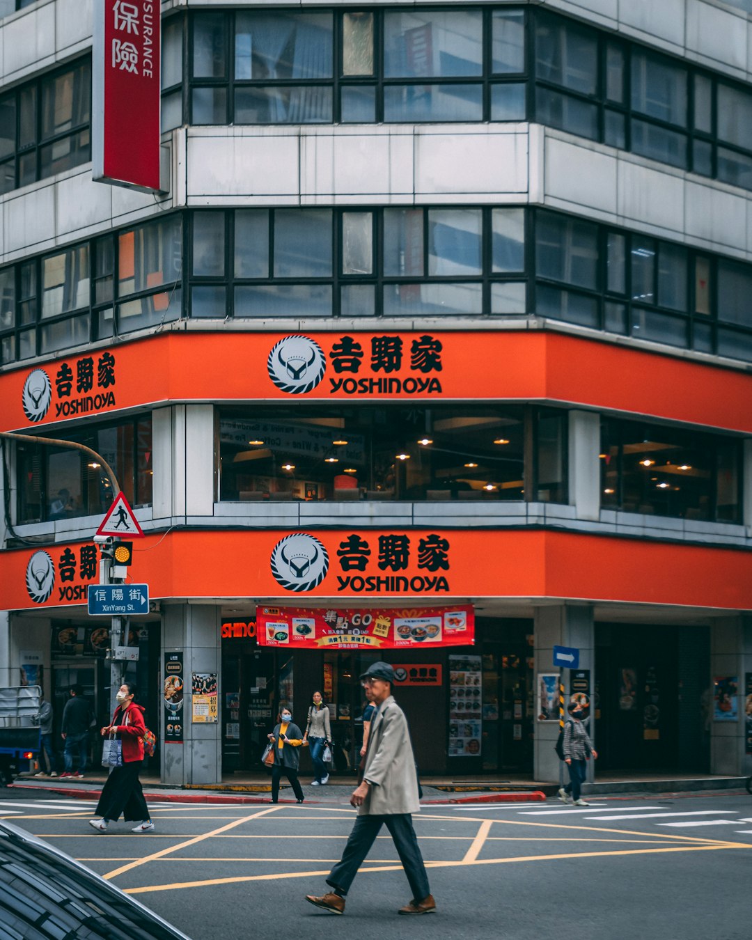 people walking on pedestrian lane near red and white concrete building during daytime