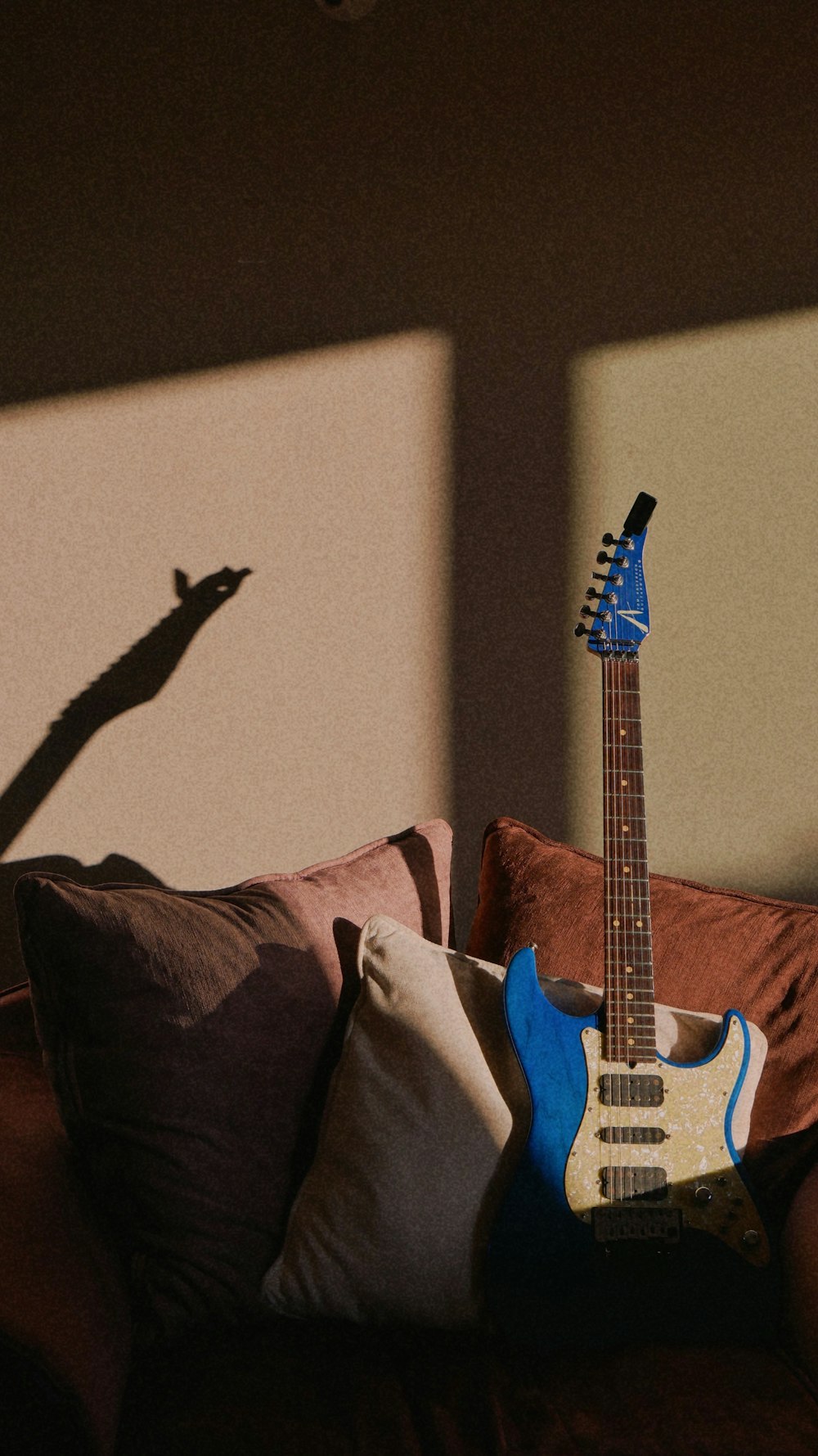 blue and white stratocaster electric guitar on black and white bed