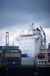 white and blue cargo ship on dock during daytime