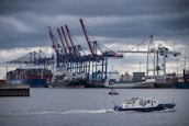 A cargo ship being inspected in a busy port, showcasing maritime operations.