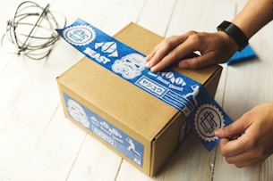 person holding brown and blue box