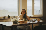 woman in black tank top sitting on chair in front of table