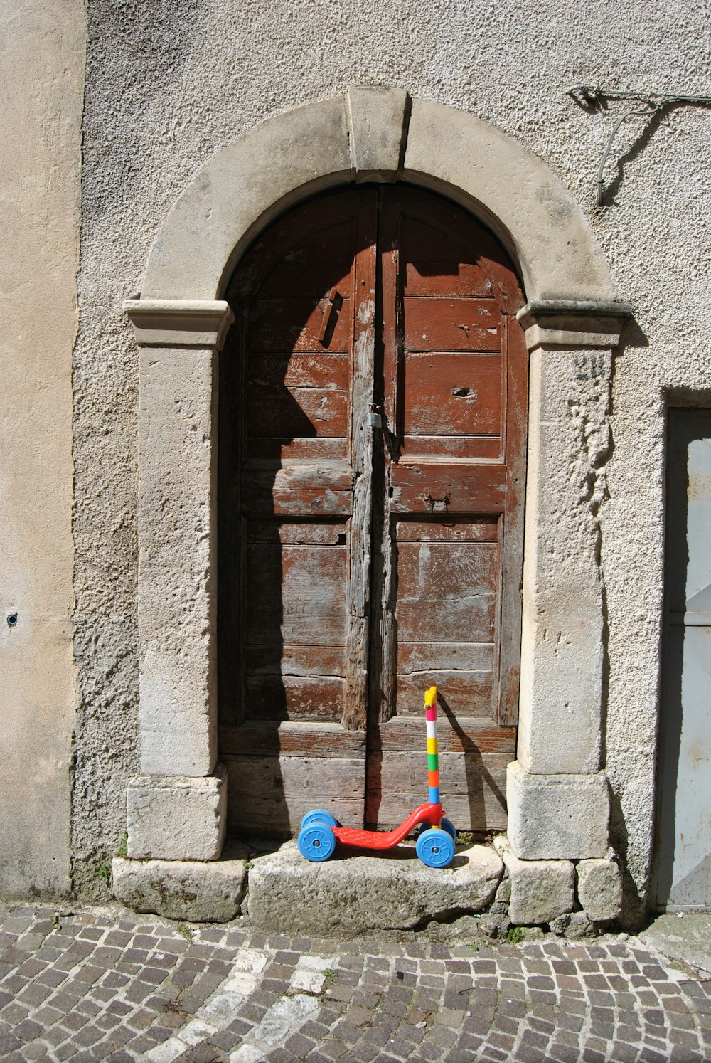 blue and red plastic toy beside brown wooden door