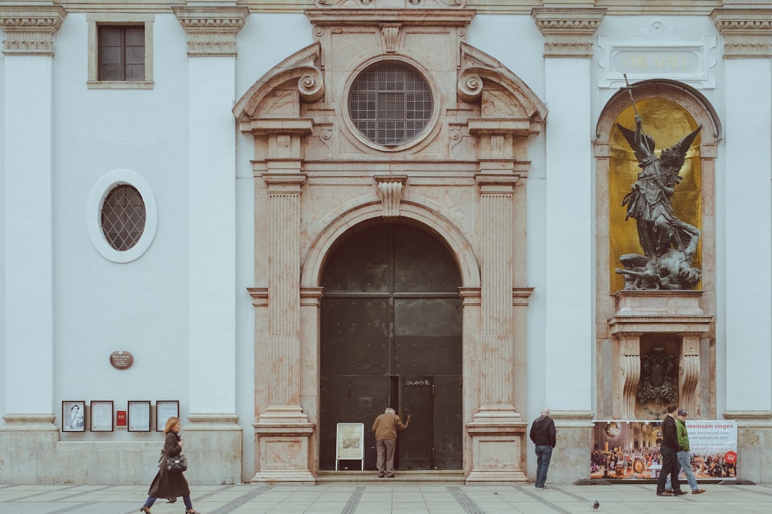 man in black jacket walking near brown wooden door during daytime