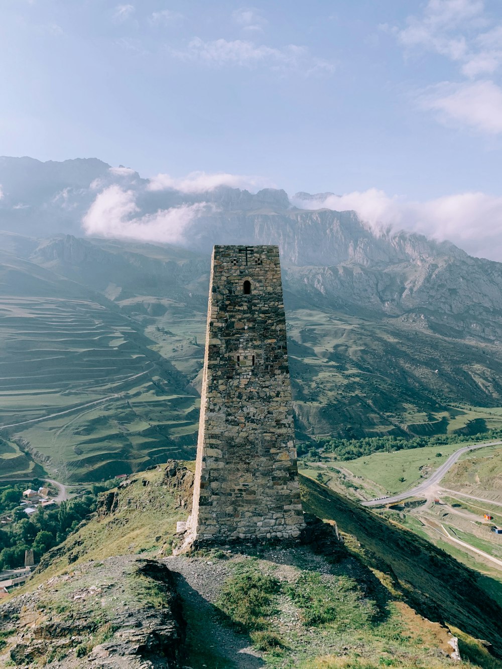 brown brick tower on green grass field