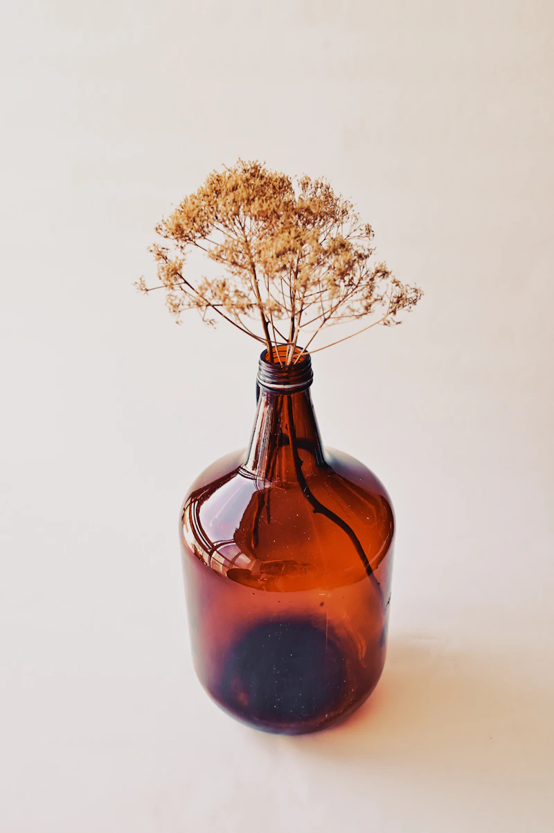 An amber glass bottle with dried flowers