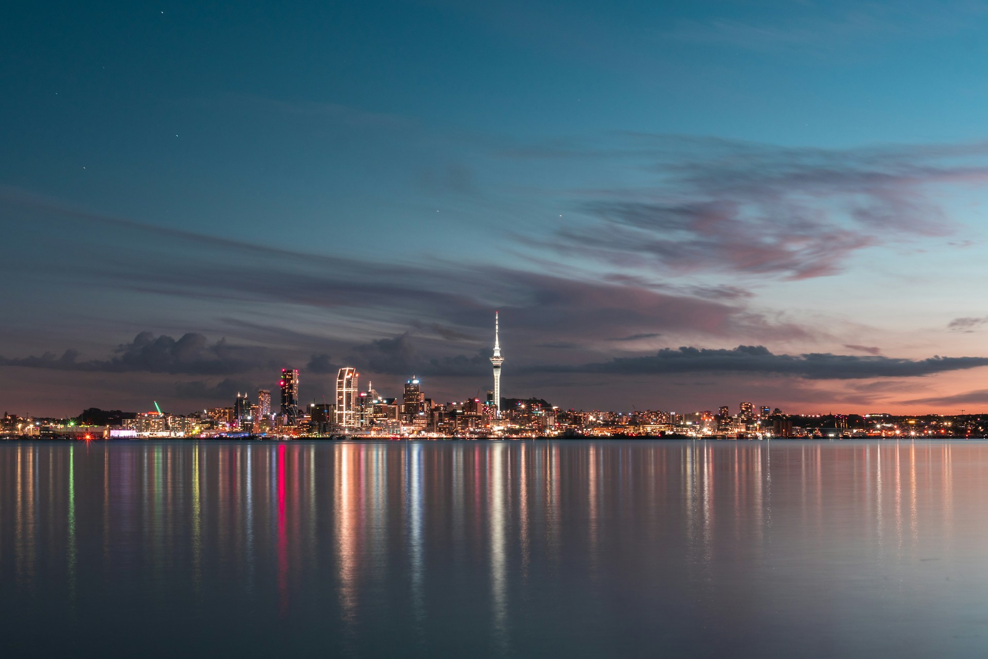 city skyline across body of water during night time