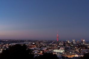 A red-tinted city skyline at dusk, blending news and stories