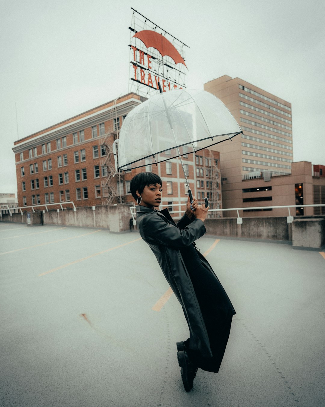 woman in black coat holding umbrella