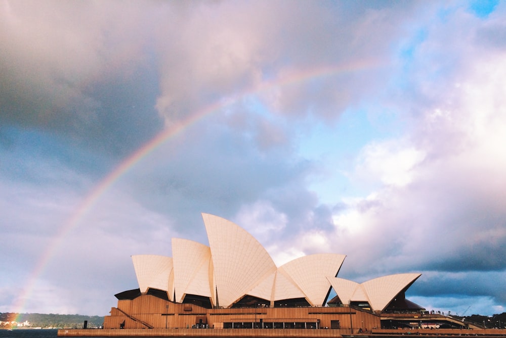 white concrete building under rainbow