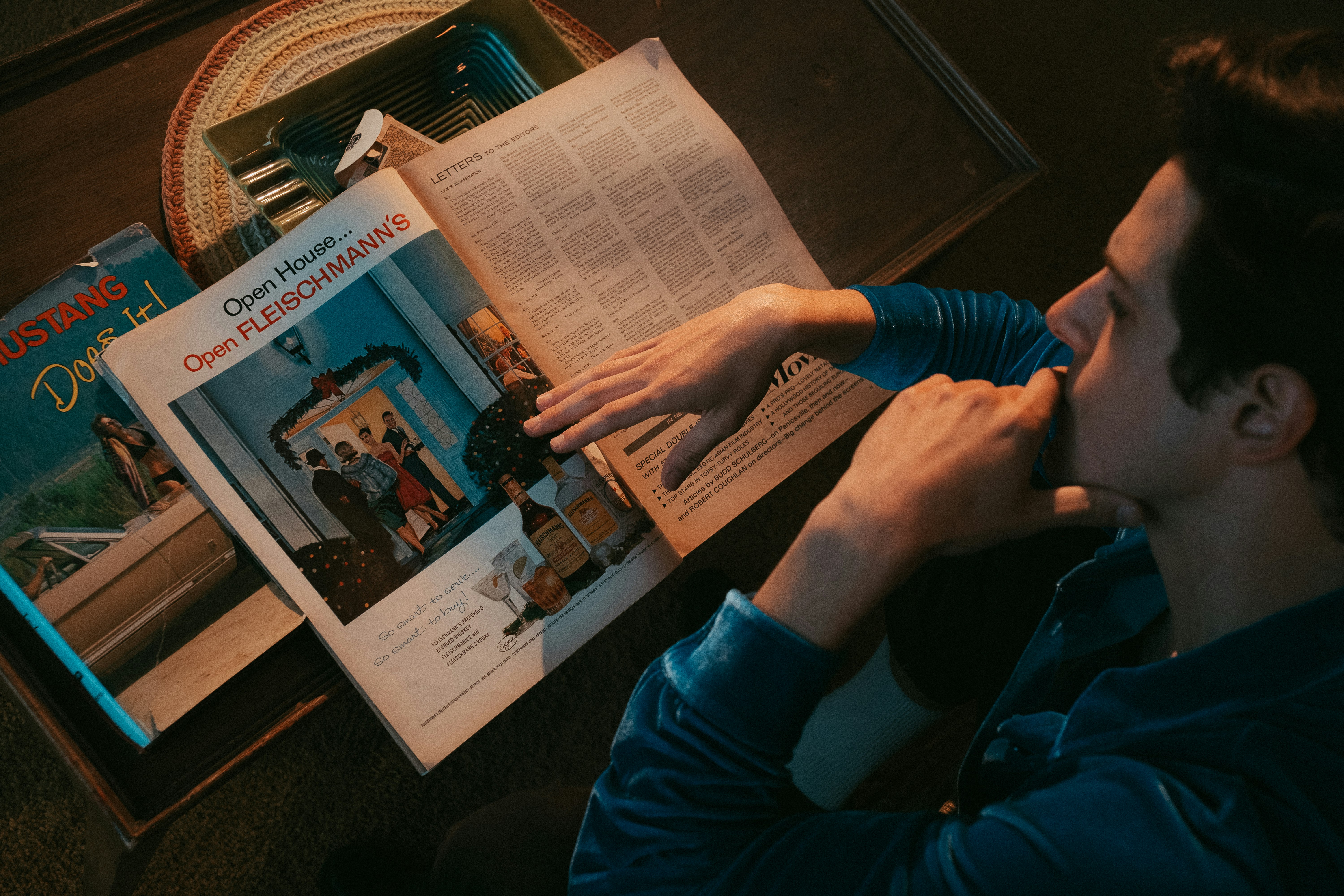 person in blue long sleeve shirt holding newspaper