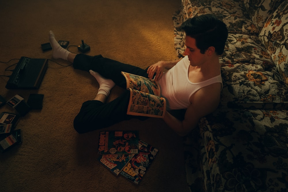 woman in white tank top and black pants sitting on brown carpet