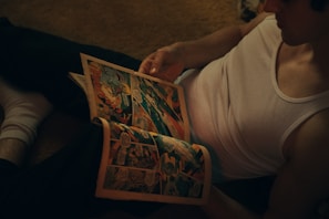 Person reading a fanzine on a cozy couch with natural light