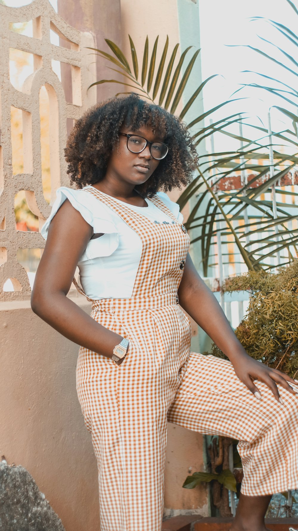 woman in white and red checked dress standing near green plants during daytime