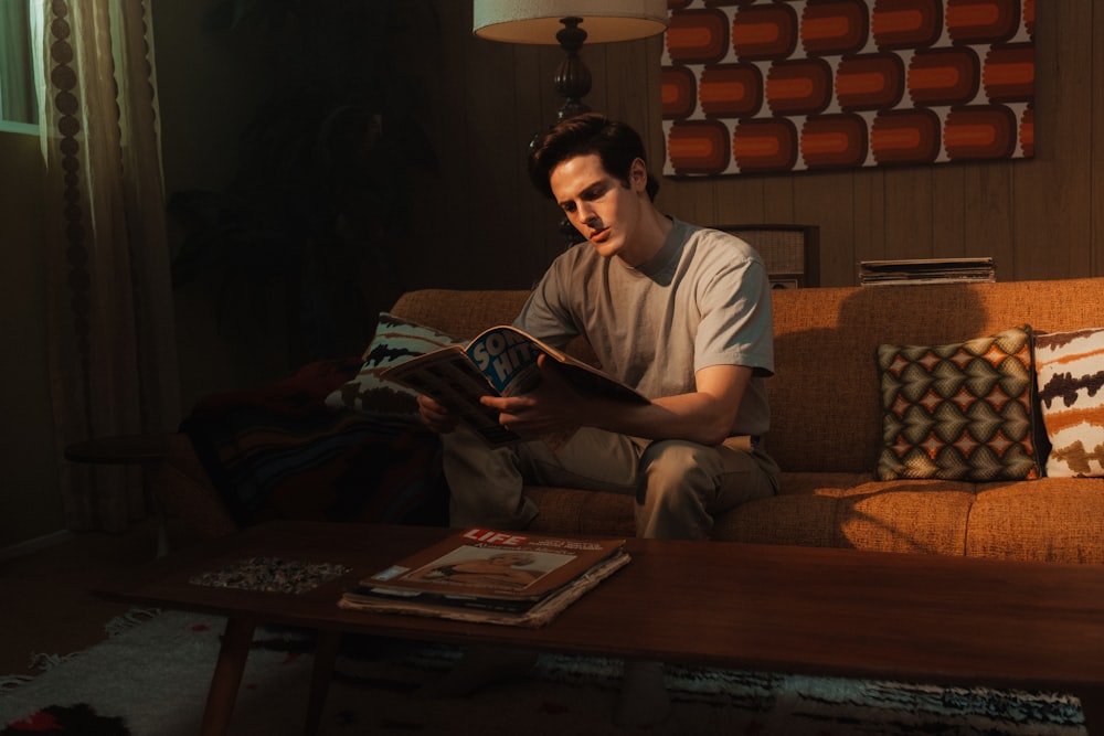 man in white crew neck t-shirt sitting on brown sofa