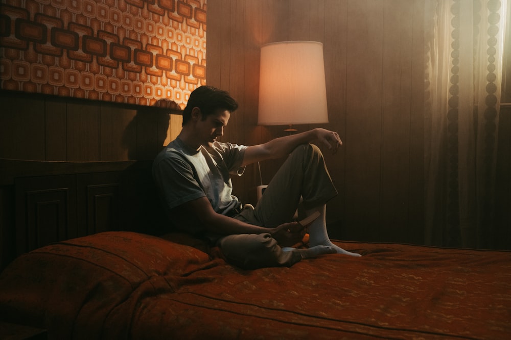 man in black long sleeve shirt sitting on bed