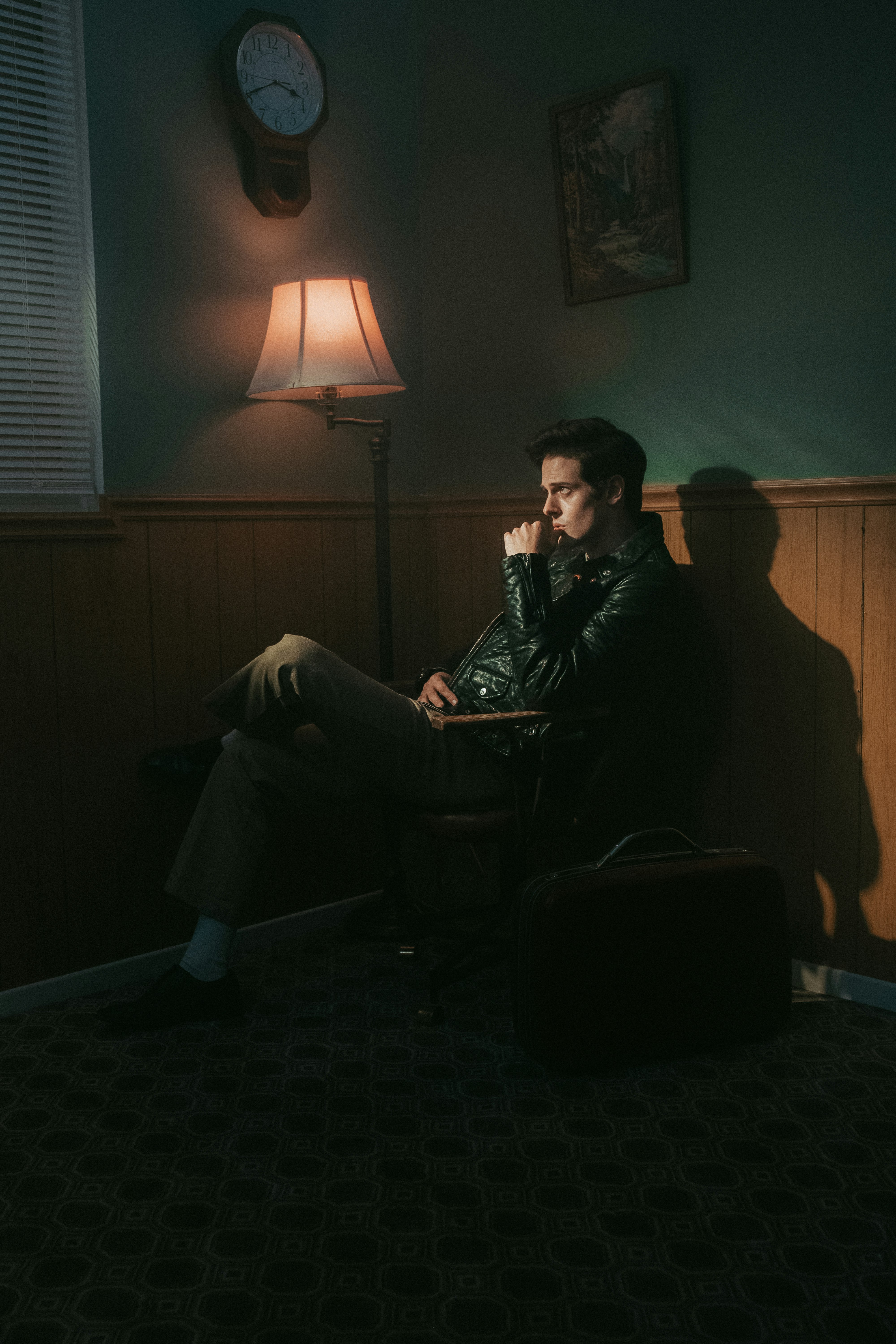 man in black jacket sitting on chair