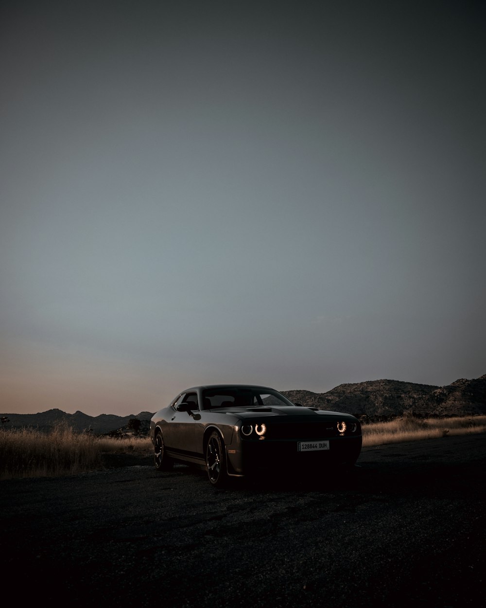 black porsche 911 on brown field during daytime