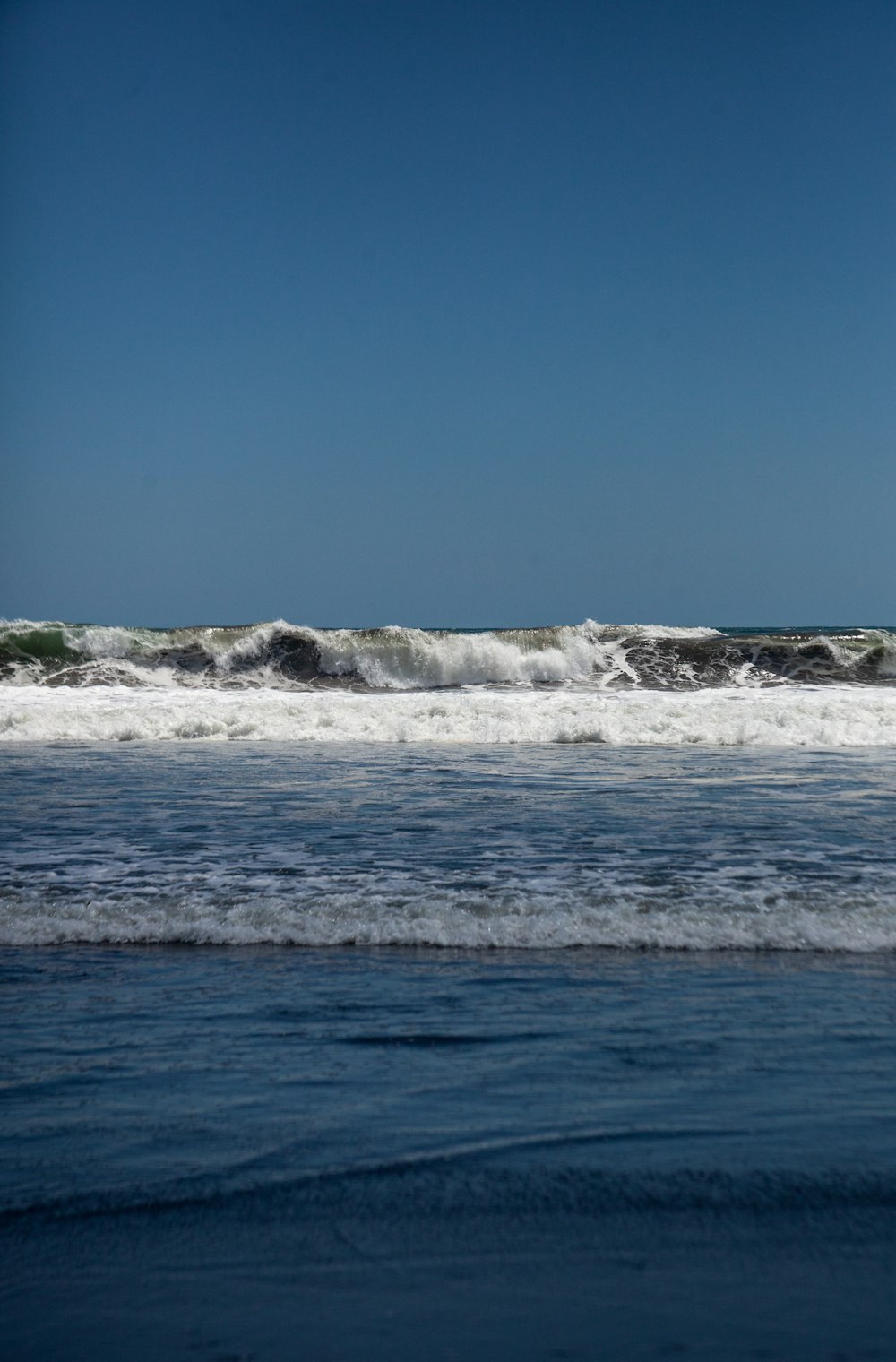 ocean waves crashing on shore during daytime