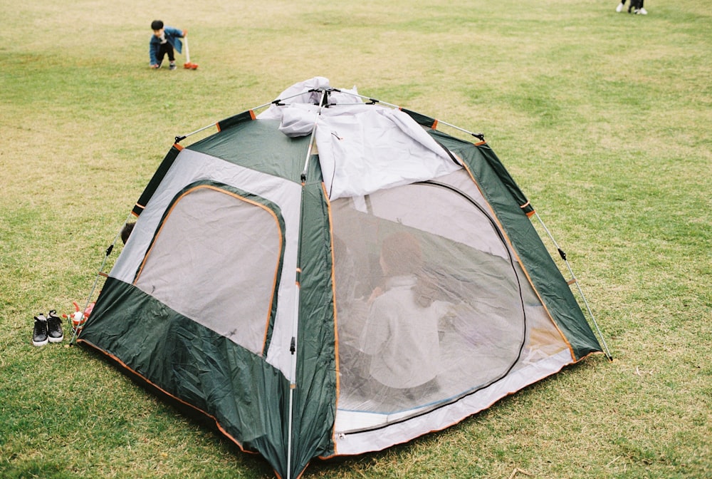 green and white dome tent on green grass field during daytime