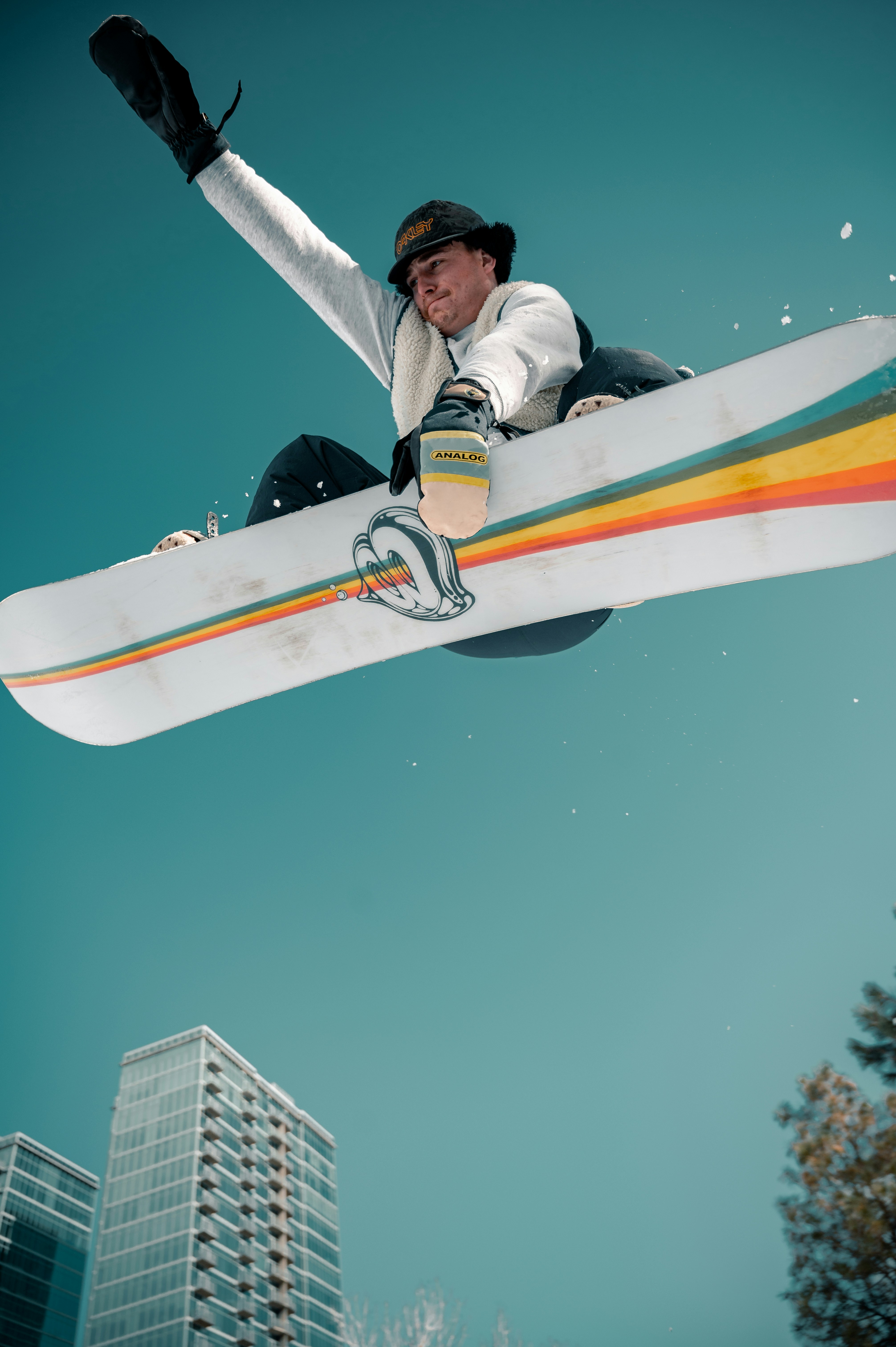 Gündüz vakti turuncu sörf tahtasının üzerinde siyah ceketli bir adam