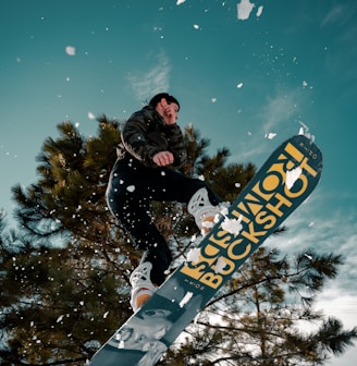 man in black jacket riding blue snowboard during night time