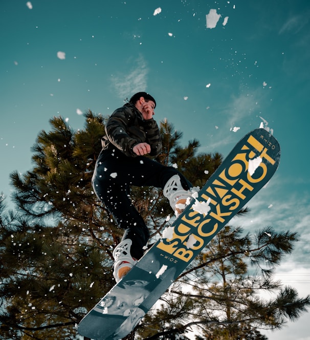 man in black jacket riding blue snowboard during night time