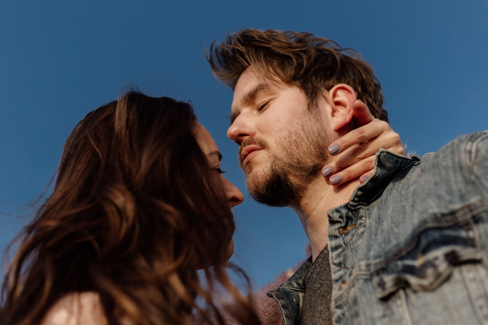 man in grey and black shirt kissing womans cheek