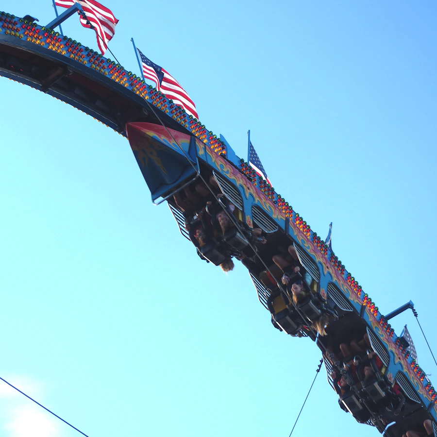 A thrill ride swinging riders against a blue sky
