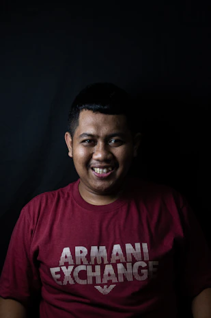 A smiling customer wearing a charcoal Avila Apparel shirt against a clean off-white background.