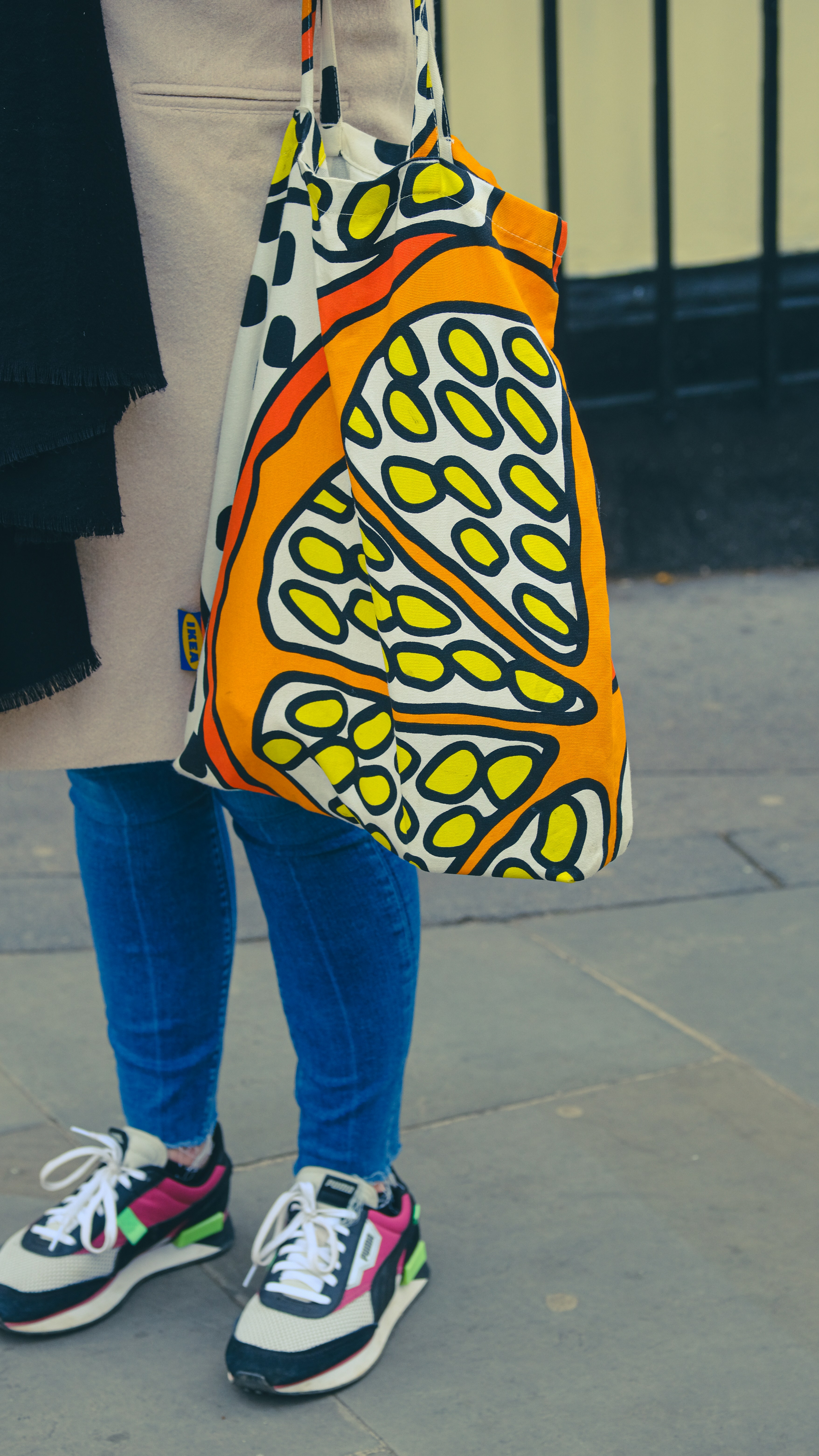 person in blue denim jeans and yellow black and white floral handbag