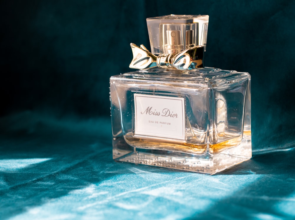 Clear glass perfume bottle on blue textile photo – Free Dior Image on  Unsplash