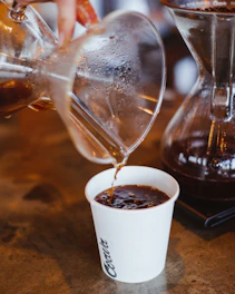 Freshly brewed pour-over coffee with visible steam rising in sunlight.