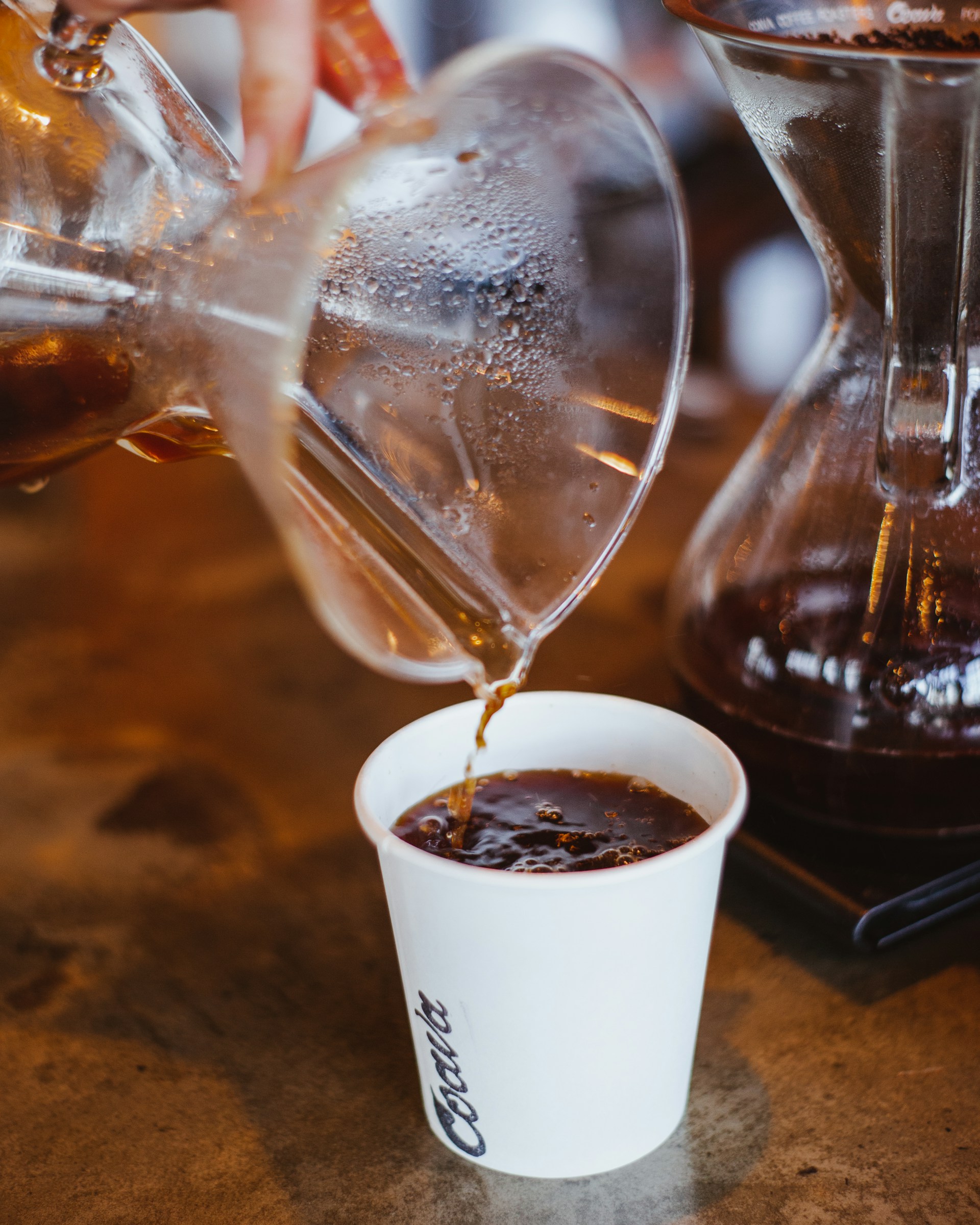 Freshly brewed coffee being poured into a ceramic cup at the cafeteria corner of the service station.