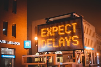 ‘Expect Delays’ sign, symbolizing the gradual process and patience required for hair restoration.