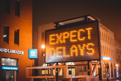 ‘Expect Delays’ sign, symbolizing the gradual process and patience required for hair restoration.