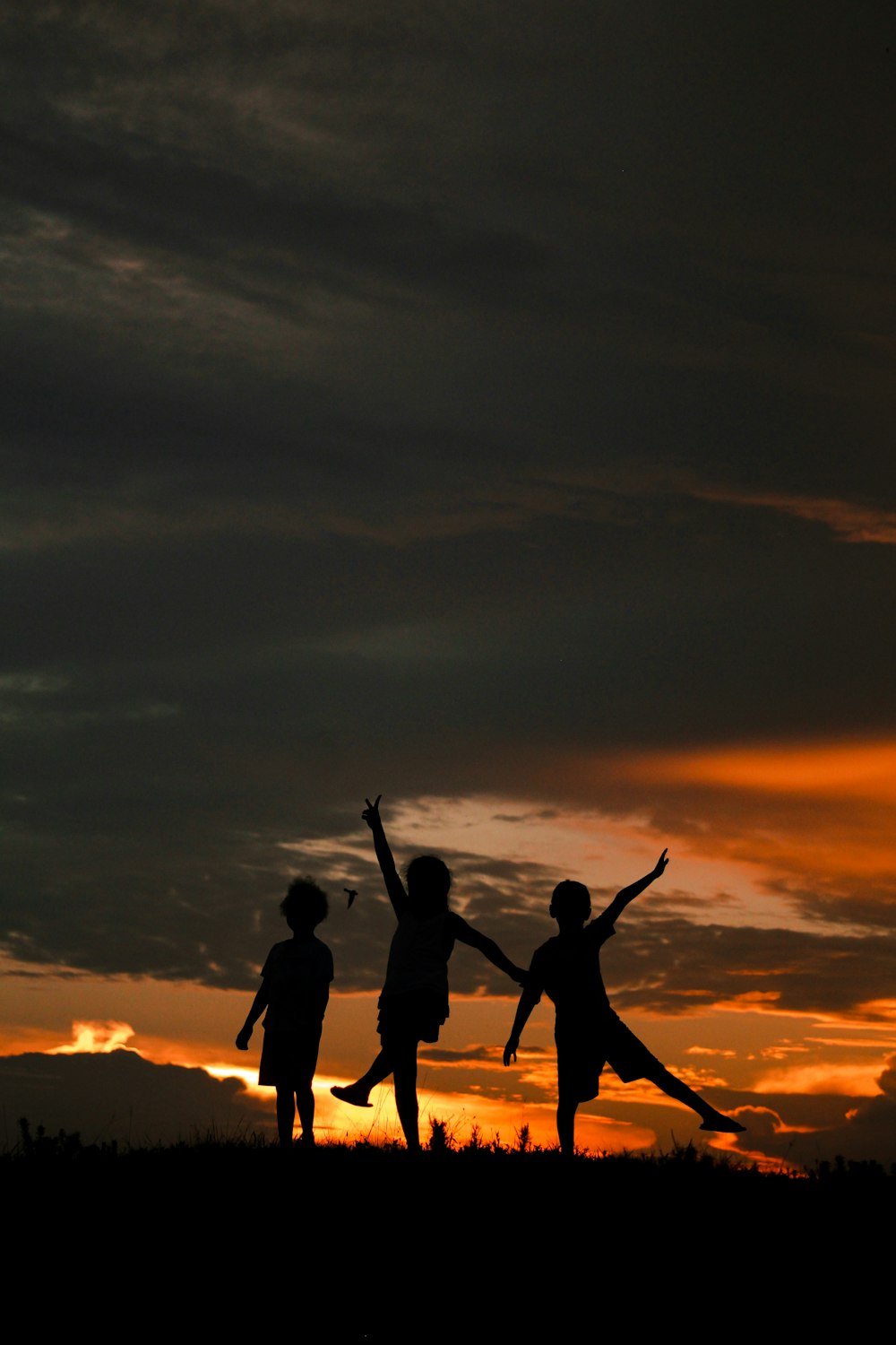 silhouette of people standing on beach during sunset