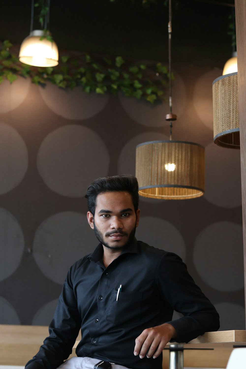 man in black jacket standing near brown pendant lamp