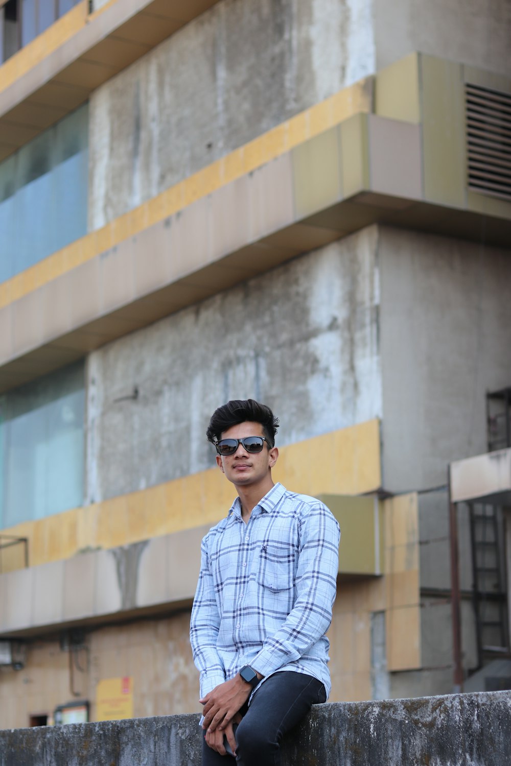 man in blue and white plaid dress shirt wearing black sunglasses