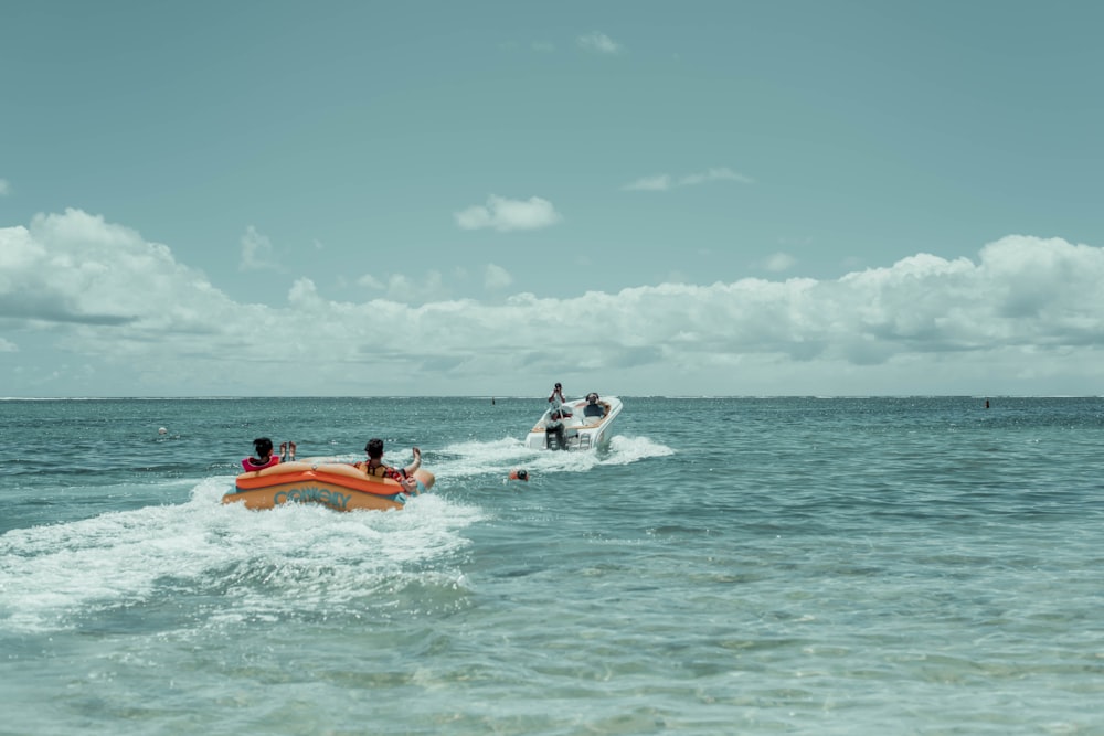 barco inflável laranja e branco no mar durante o dia
