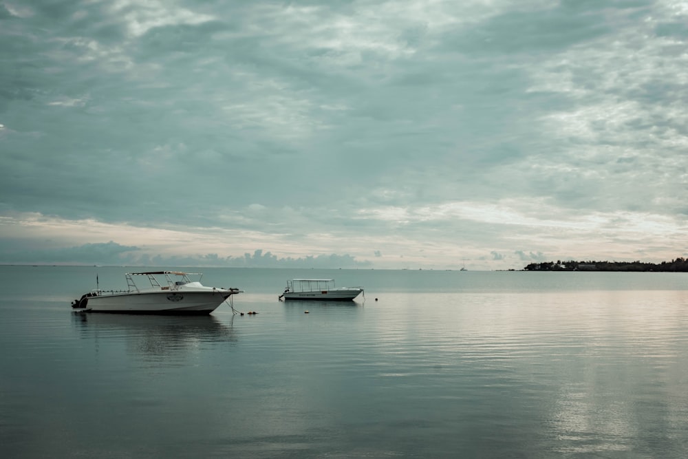 white boat on sea under cloudy sky during daytime