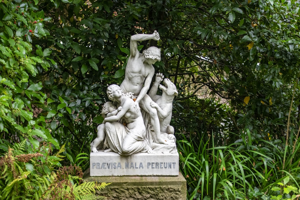 woman in dress statue near green plants