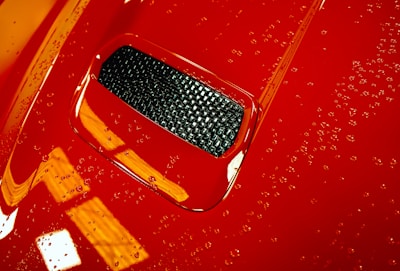 Close-up of a shiny car surface after vitrification treatment under natural light.