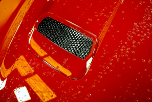 Side view of a shiny, wet-look exterior finish on a sleek sedan