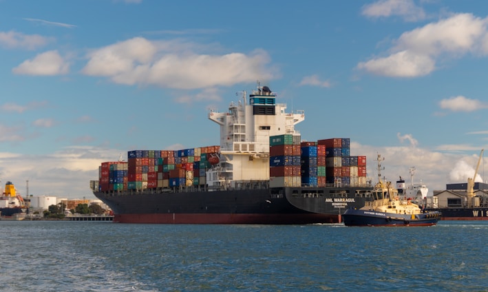 cargo ship on sea under blue sky during daytime